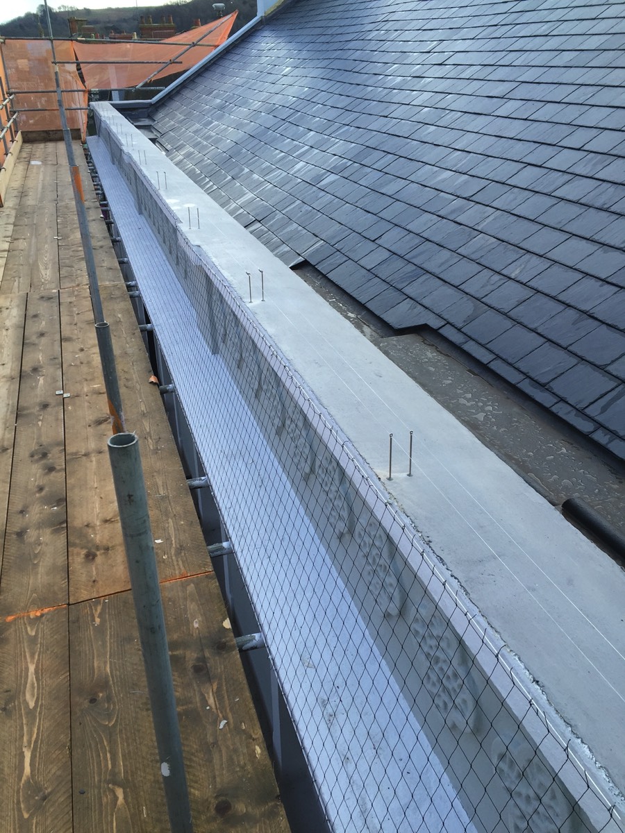 Installation of a combination of a post and wire system and pigeon netting as part of external redecoration works.